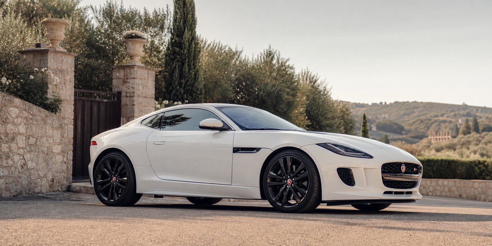 Jaguar F-Type bianca vista di profilo su strada verso il ricevimento